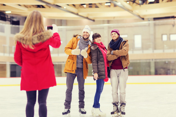 happy friends taking photo on skating rink - Zdjęcie, obraz