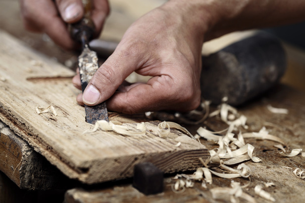 Manos de carpintero trabajando con un cincel y herramientas de tallado
 - Foto, Imagen