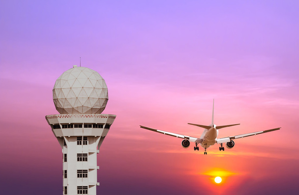 Luchthaven controletoren en commerciële vliegtuig landing bij zonsondergang - Foto, afbeelding