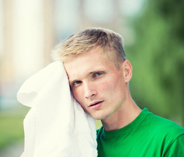 Unavený člověk po čase fitness a cvičení. S bílým ručníkem - Fotografie, Obrázek