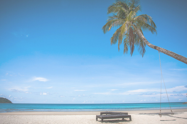 kookospuu ja ranta puinen sänky valkoisella hiekalla kaunis sininen meri yli kirkas sininen taivas
 - Valokuva, kuva