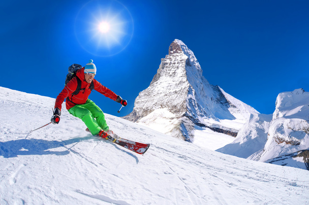 Skier skiing downhill against Matterhorn peak in Switzerland - Fotografie, Obrázek