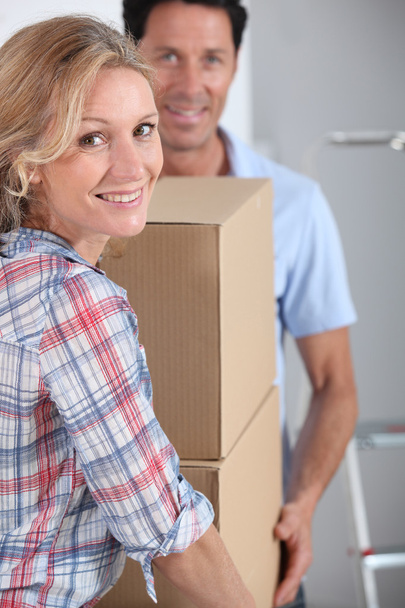 Couple carrying packing boxes into new home - Photo, image