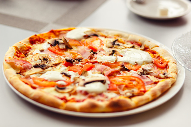 Pizza au fromage Mozzarella, tomates fraîches et champignons
 - Photo, image