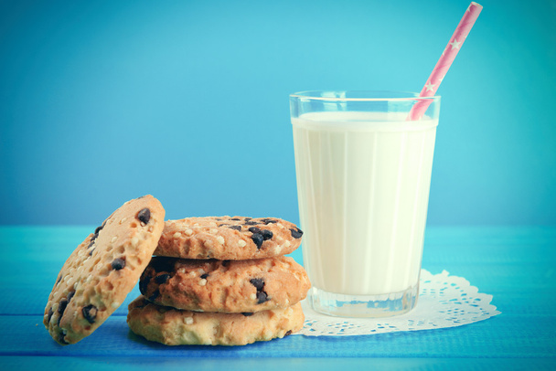 Tasty cookies and glass of milk on table on blue background - Photo, Image