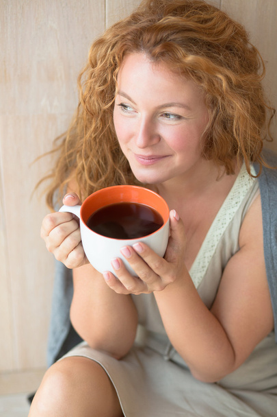 Middle-aged woman with a cup of tea - Foto, afbeelding