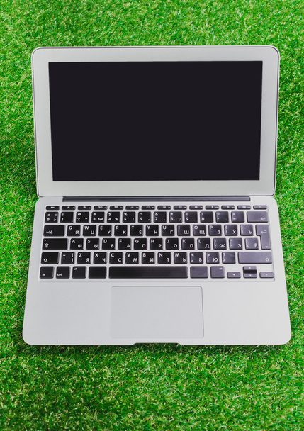 blank notebook, phone, laptop and headphone on green grass - Φωτογραφία, εικόνα