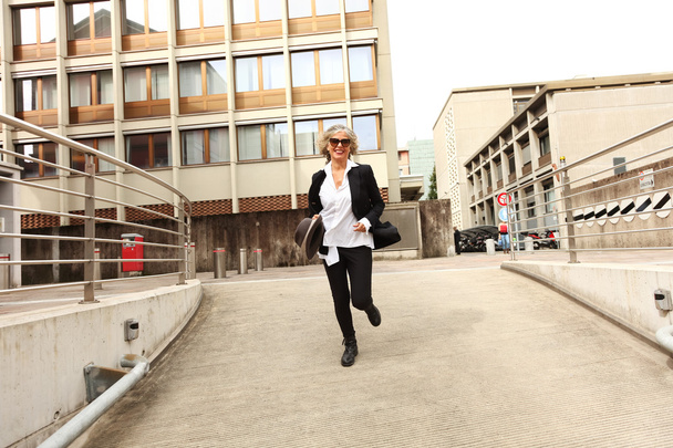 зріла бізнес-леді біжить за містом
 - Фото, зображення