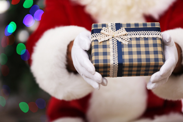 Santa holding gift - Zdjęcie, obraz