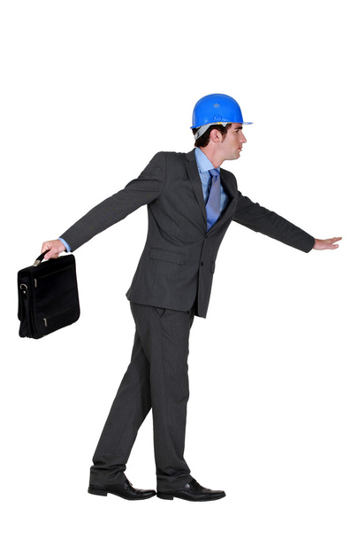 Elated foreman in suit holding briefcase against white background - Valokuva, kuva