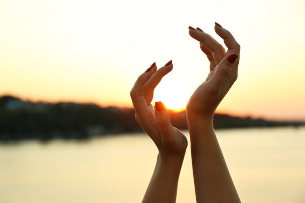 Mãos femininas no céu ensolarado
  - Foto, Imagem