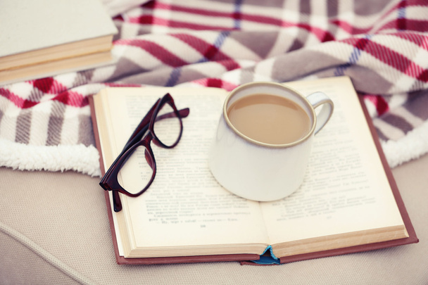 リビング ルームのソファの上の本とコーヒーのカップ - 写真・画像