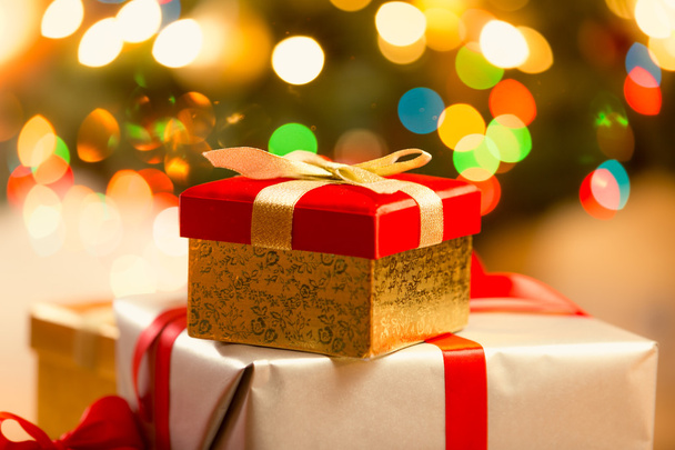 Primo piano della confezione regalo di Natale rossa con nastro dorato e fiocco
 - Foto, immagini