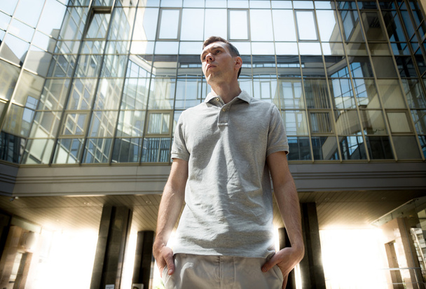 young man posing against glass wall at business center - Φωτογραφία, εικόνα