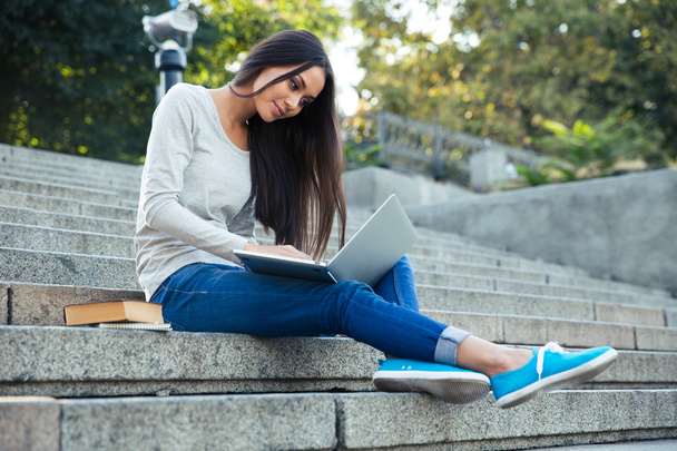 Girl sitting on the city stairs with laptop outdoors - Fotografie, Obrázek
