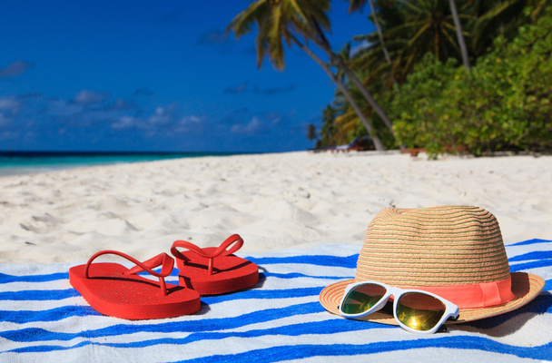 hat, sun glasses and flip flops on a tropical beach - Photo, Image