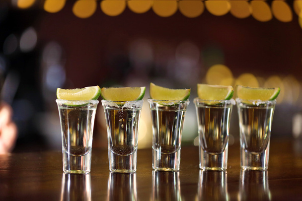 Shot glasses with tequila on bar counter - Foto, afbeelding