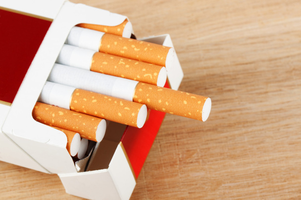 Cigarrillos en paquete en la tabla de pan
 - Foto, Imagen