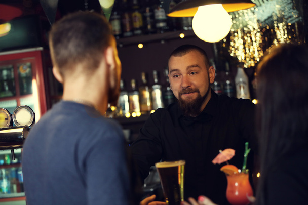 Young man and woman drinking in bar - Φωτογραφία, εικόνα