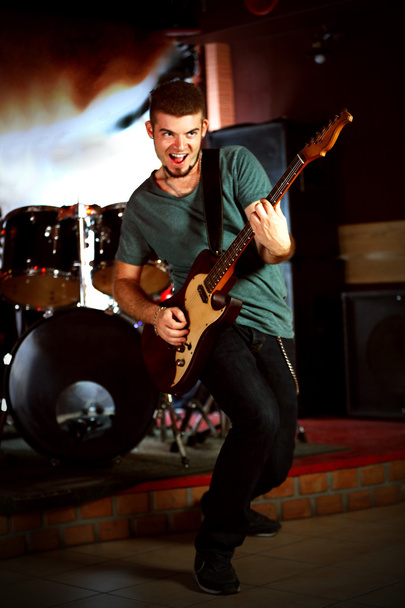 Young man playing on electric guitar at pub - Fotó, kép
