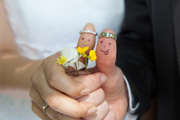snubní prsteny na jejich prstech vybarvené nevěsta a ženich, legrační lidiček - Fotografie, Obrázek