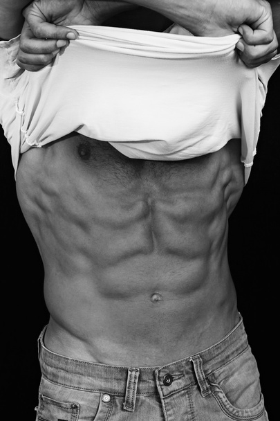 Muscular Men, perfect body, abs, six pack. Strong athletic guy in jeans showing his abs. Bodybuilding, sport, fitness ,workout, active lifestyle concept. Black and white photo - Photo, image