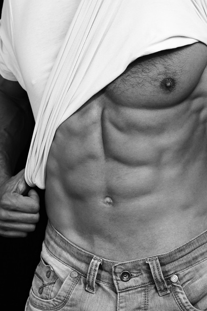 Muscular Men, perfect body, abs, six pack. Strong athletic guy in jeans showing his abs. Bodybuilding, sport, fitness ,workout, active lifestyle concept. Black and white photo - Foto, afbeelding