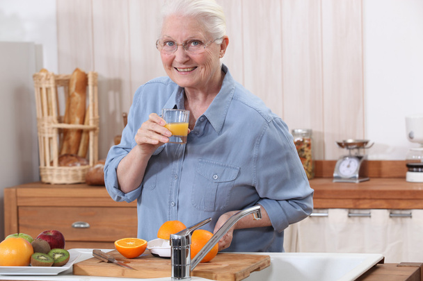 Старушка делает апельсиновый сок
. - Фото, изображение
