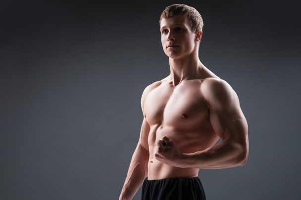 Muscular young man  shows the different movements and body parts - Foto, Imagem