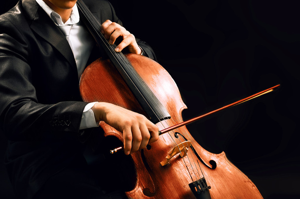 Man playing on cello on dark background - Foto, immagini