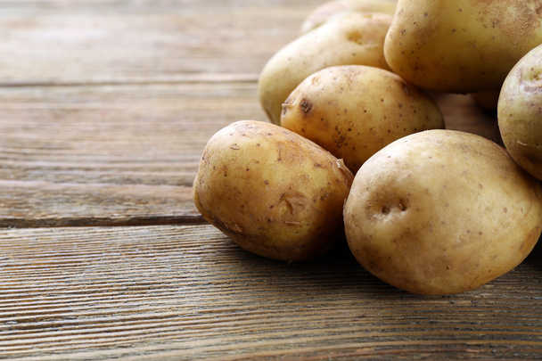 Young potatoes on wooden table close up - Foto, afbeelding