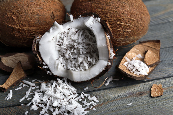 Coconut shavings in coconut on wooden background - Photo, Image
