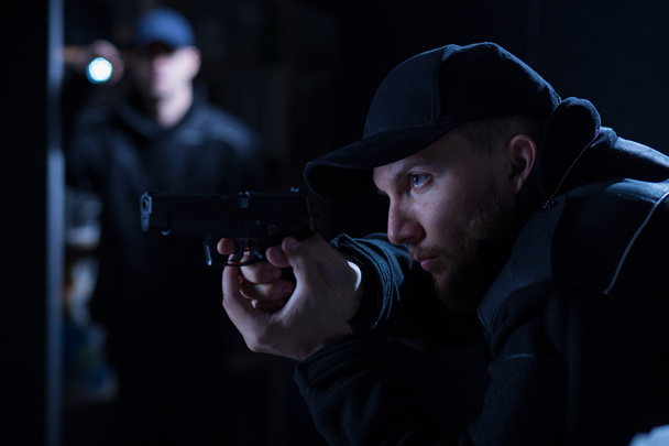 Police officer holding handgun - Фото, изображение