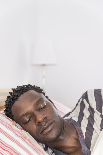 Peaceful african black man sleeping in bed - Foto, afbeelding