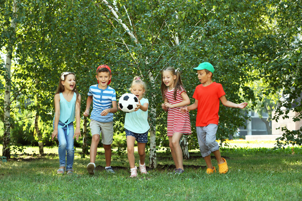 Feliz niños activos jugando con el fútbol en el parque
 - Foto, Imagen