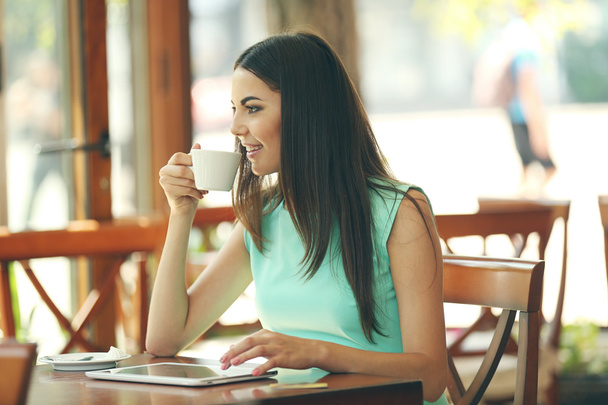 Beautiful young woman with digital tablet in cafe - Foto, imagen