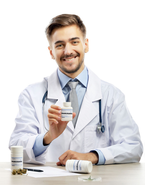 Доктор тримає пляшку з медичним канабісом ізольовано на білому
 - Фото, зображення
