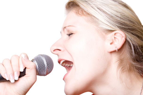 Дівчина співає з мікрофоном. Ізольовані на білому
. - Фото, зображення