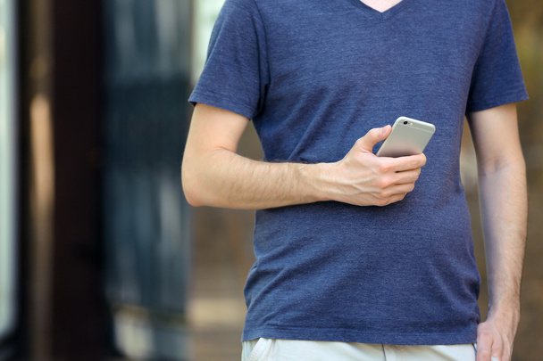 Man holding smart mobile phone outdoors - Valokuva, kuva