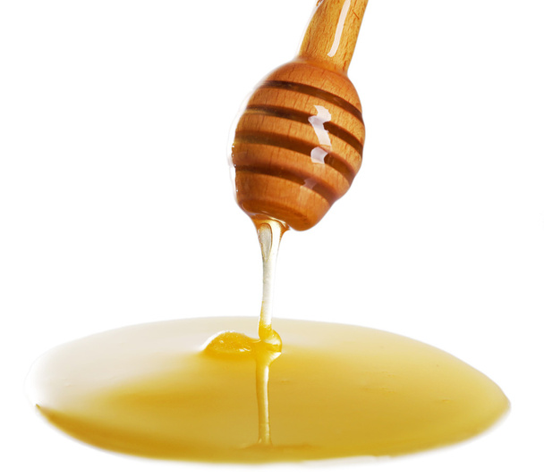 Honey dripping from dipper on light surface - Fotografie, Obrázek
