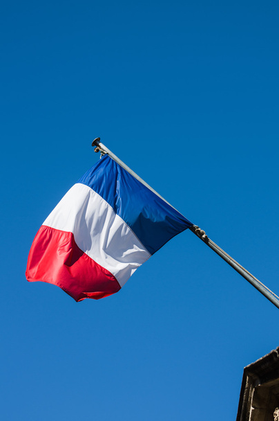Bandeira francesa contra o céu azul nublado
 - Foto, Imagem