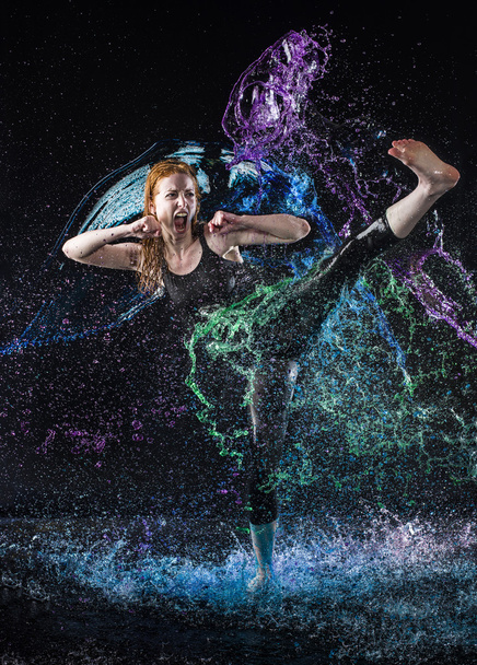 Woman High Kicking in Colorful Water Splashes - 写真・画像