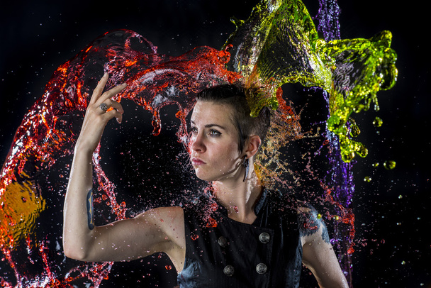 Modern Woman Being Splashed with Colorful Water - Foto, imagen