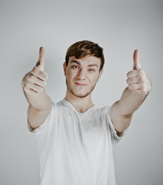 Portrait of a handsome young man showing thumbs up - Foto, Imagen