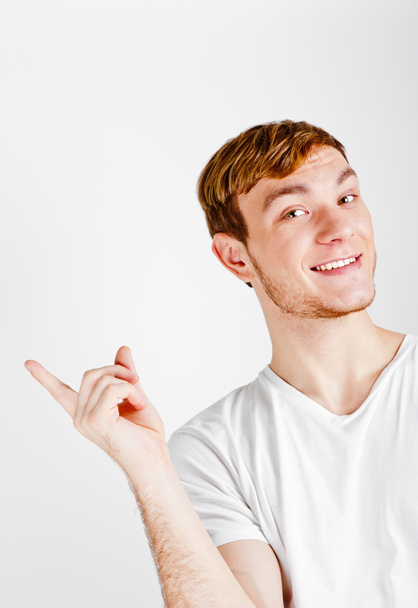 Portrait of young man pointing with finger - Фото, зображення