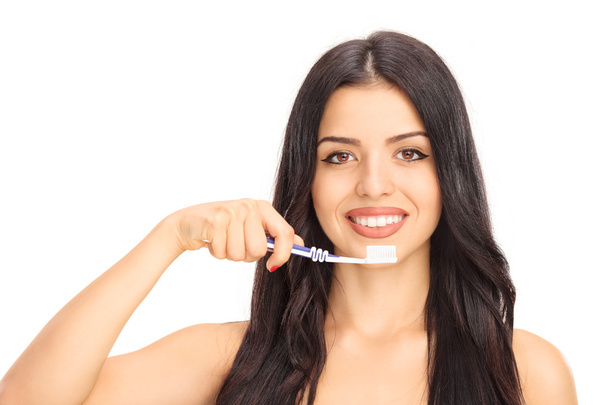 Beautiful young woman brushing her teeth - Fotó, kép
