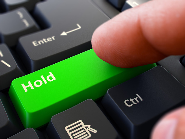 Палець натискає зелену кнопку клавіатури тримати
. - Фото, зображення
