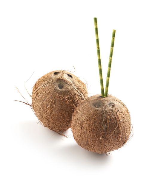 two coconuts on a white background with bamboo straws - Photo, Image