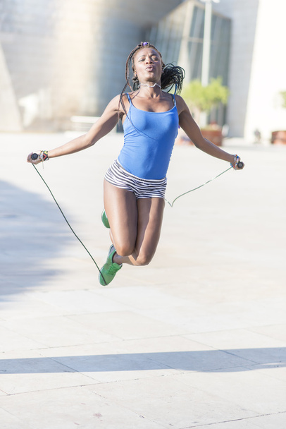 美しいアフリカ スポーツ女性縄跳び、健康的なライフ スタイルのコンセプト. - 写真・画像