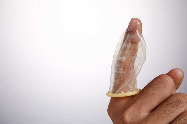 Stock image of the man holding condom - Foto, Imagen